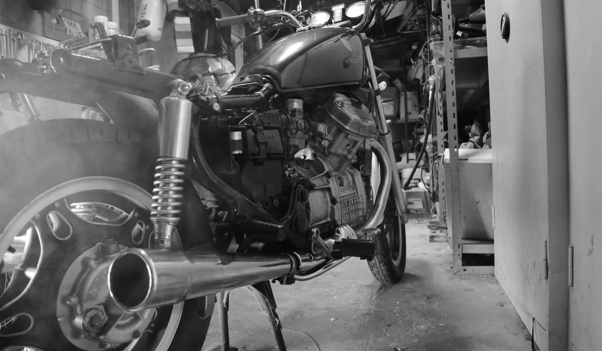 Moto ancienne photographiée en noir et blanc dans un atelier