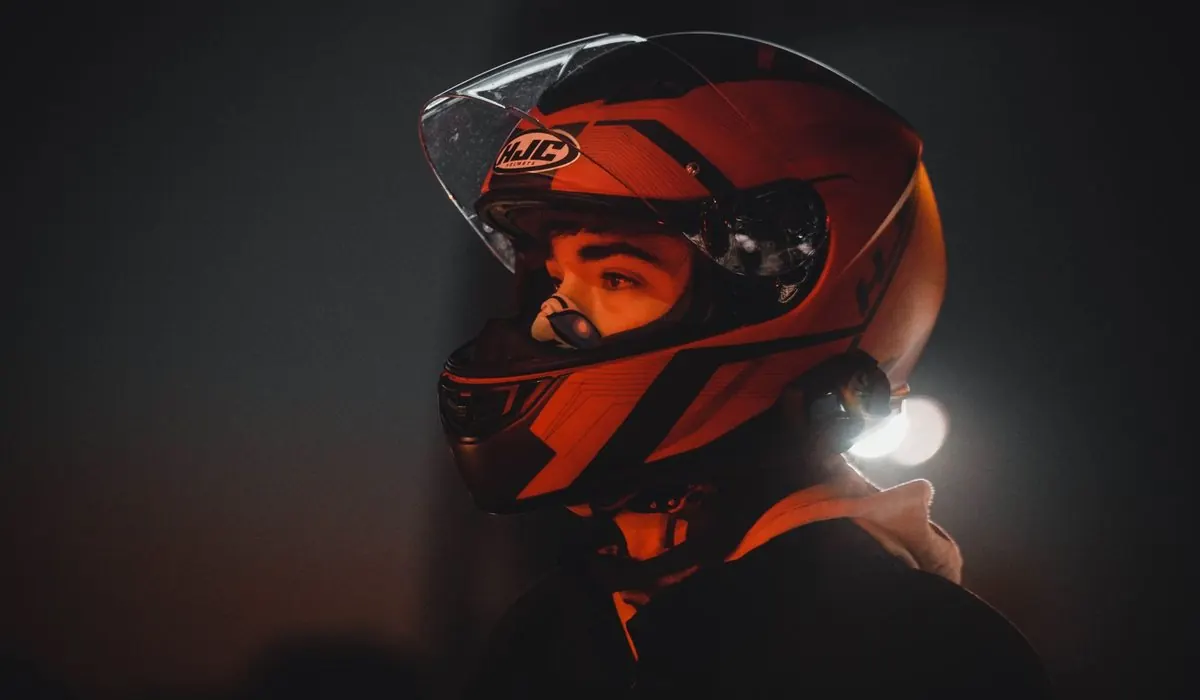 Pilote coiffé d'un casque orange, visière relevée